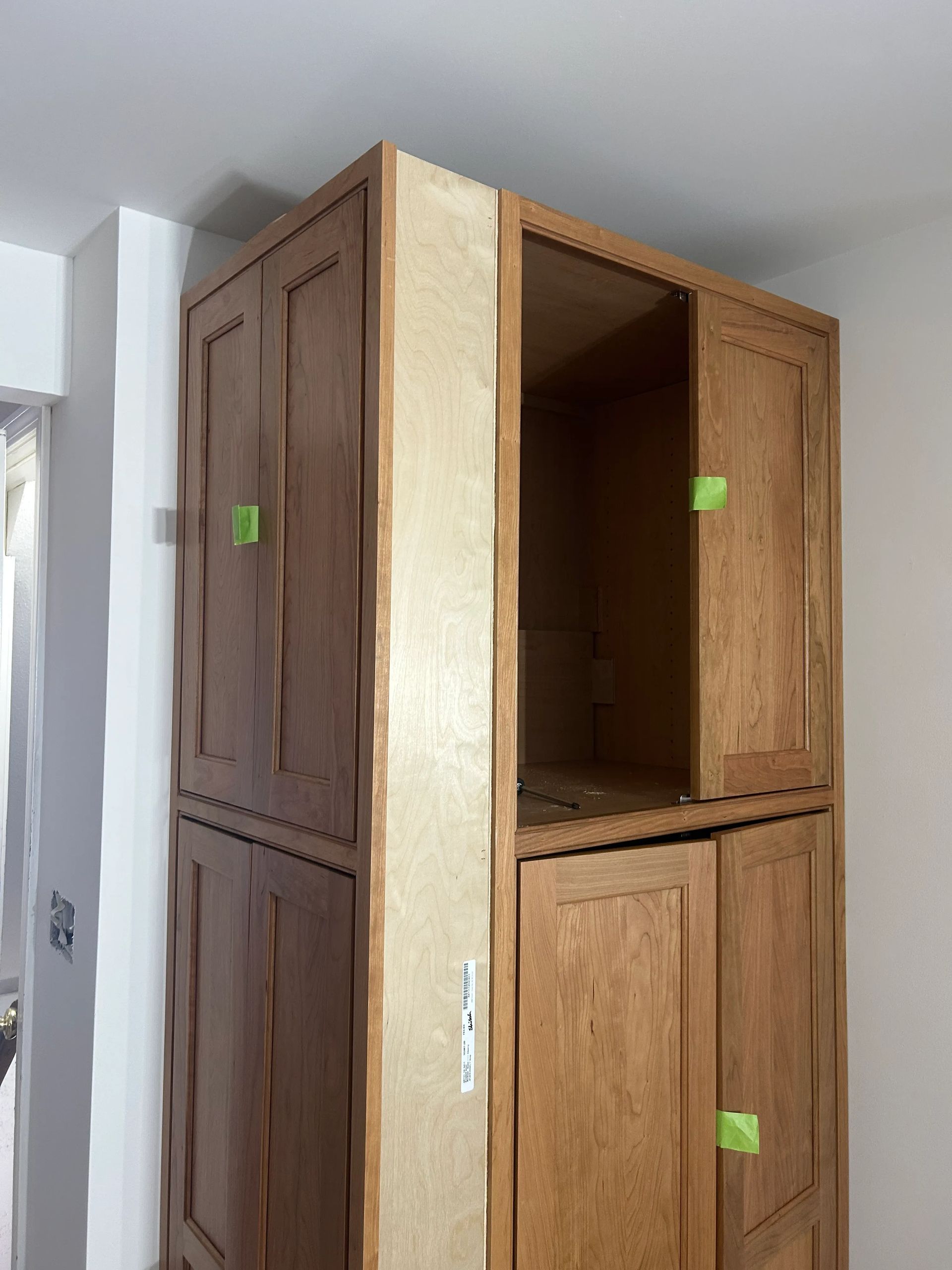 A large wooden cabinet is being built in a room.