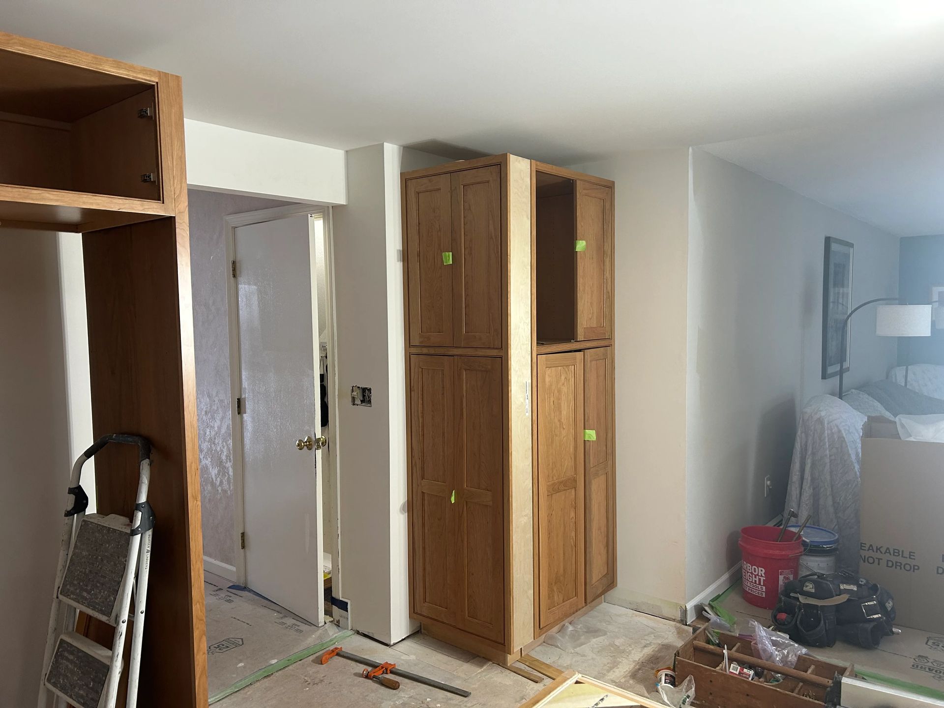 A room with wooden cabinets and a ladder in it.