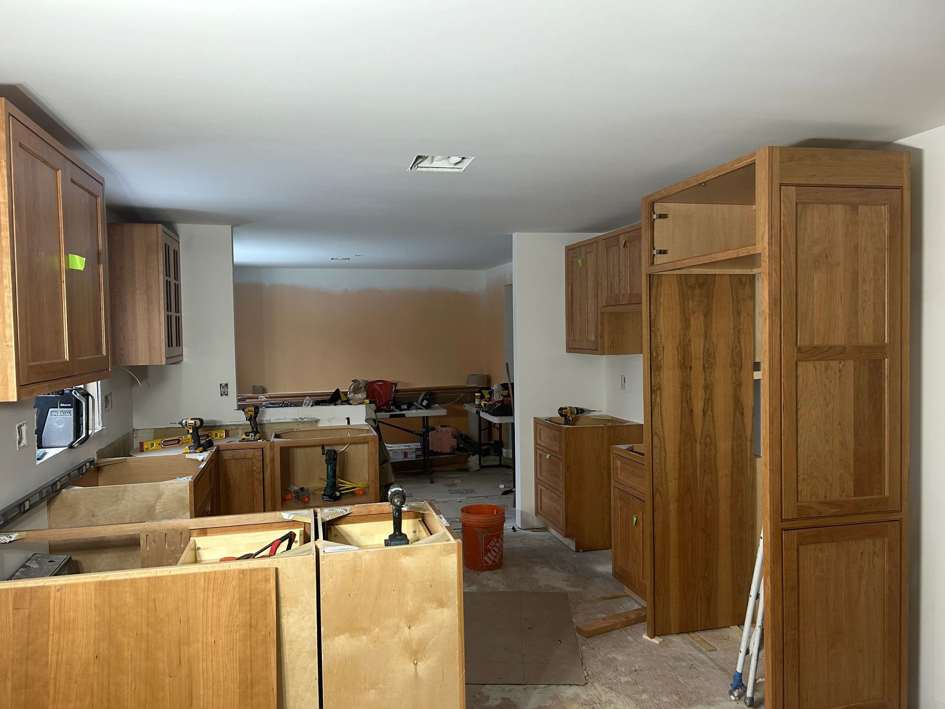 A kitchen under construction with wooden cabinets and drawers.