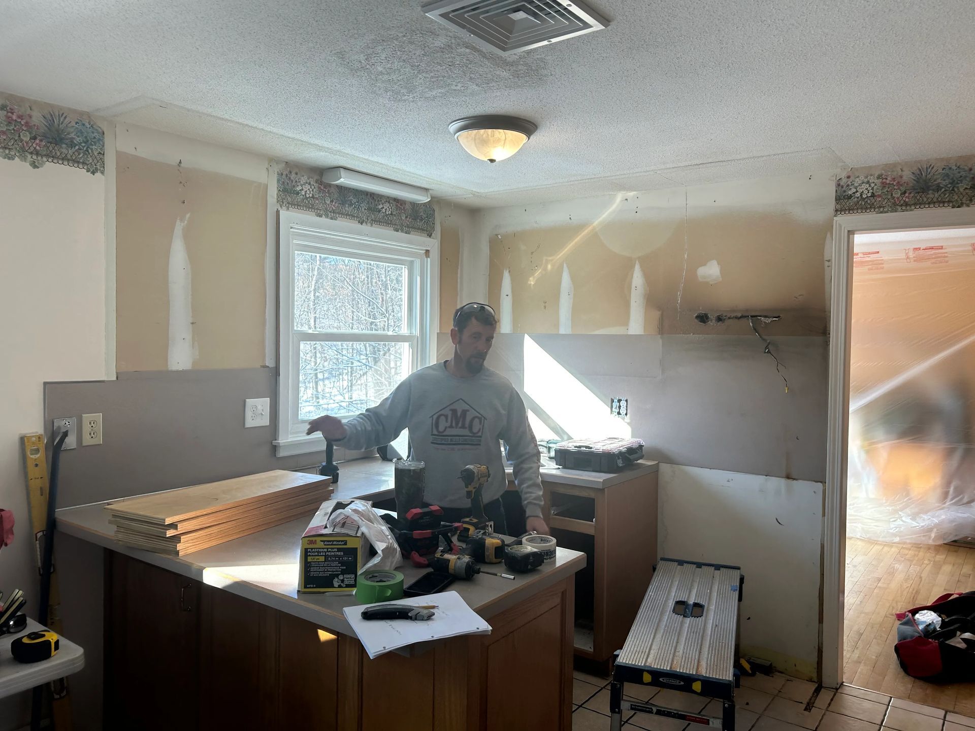 A man is working on a kitchen in a house.