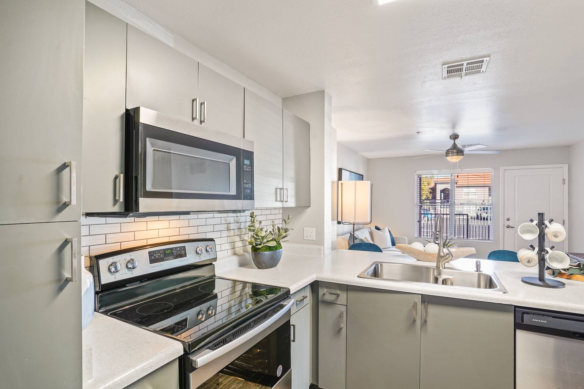 Modern kitchen with stainless steel appliances and an open living area.