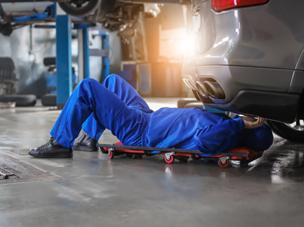 Mechanic picking up tire from rack of tires | Finger Lakes Automotive & Marine