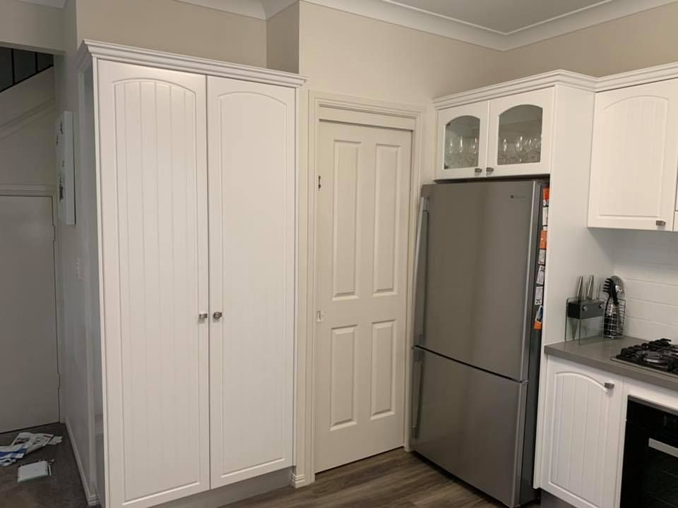 The corner of a kitchen, focusing on the large white kitchen cabinet.