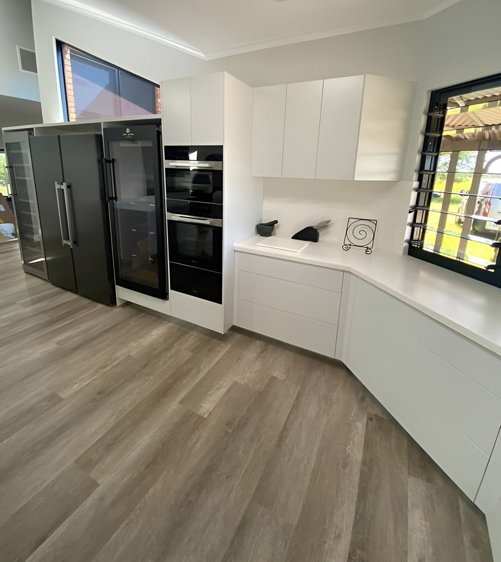 Modern White Kitchen with White Cabinets and Black Appliances — Kitchen Cabinets in Byron Bay, NSW