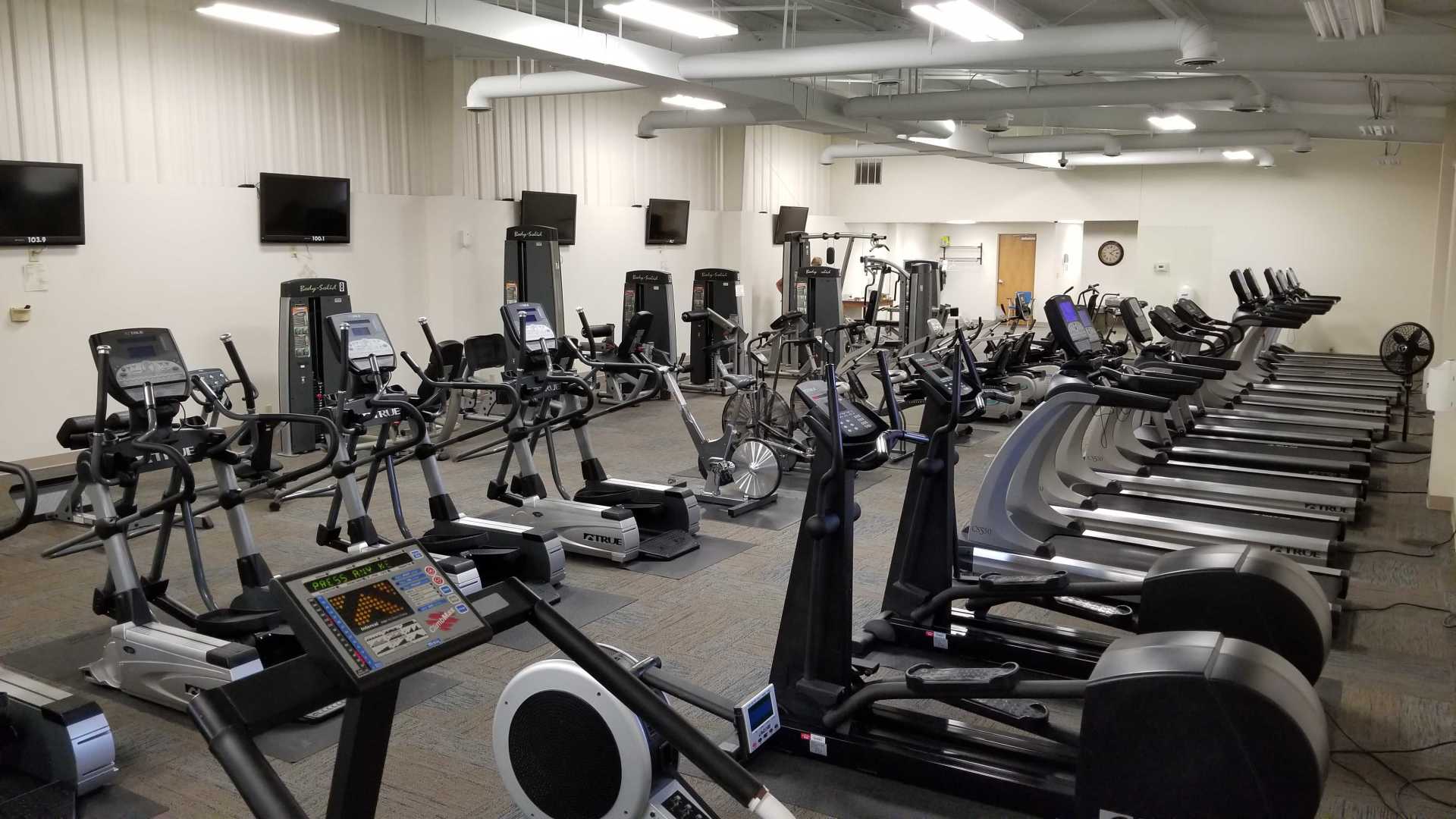 a large gym filled with lots of exercise equipment.
