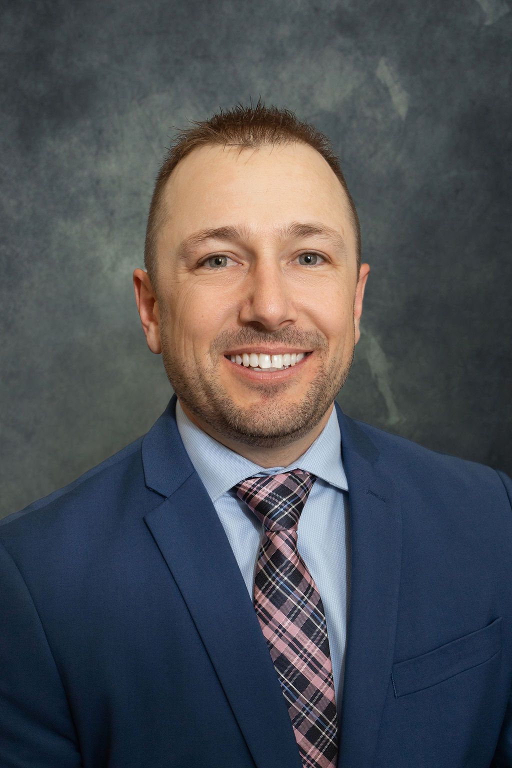 A man in a suit and tie is smiling for the camera.