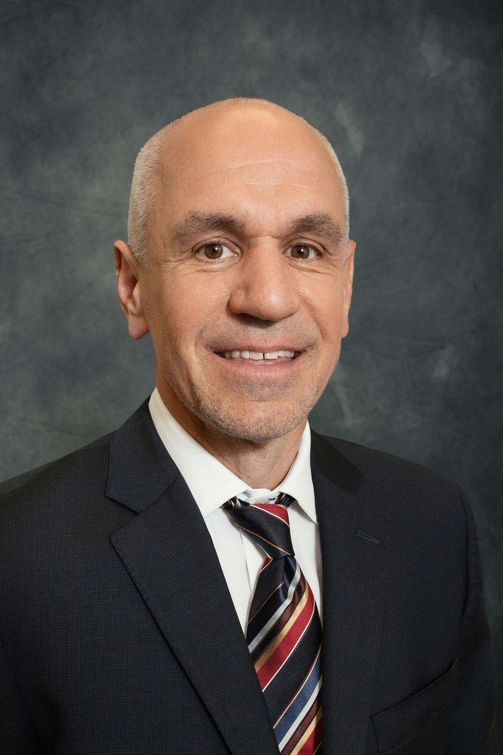 A man in a suit and tie is smiling for the camera.