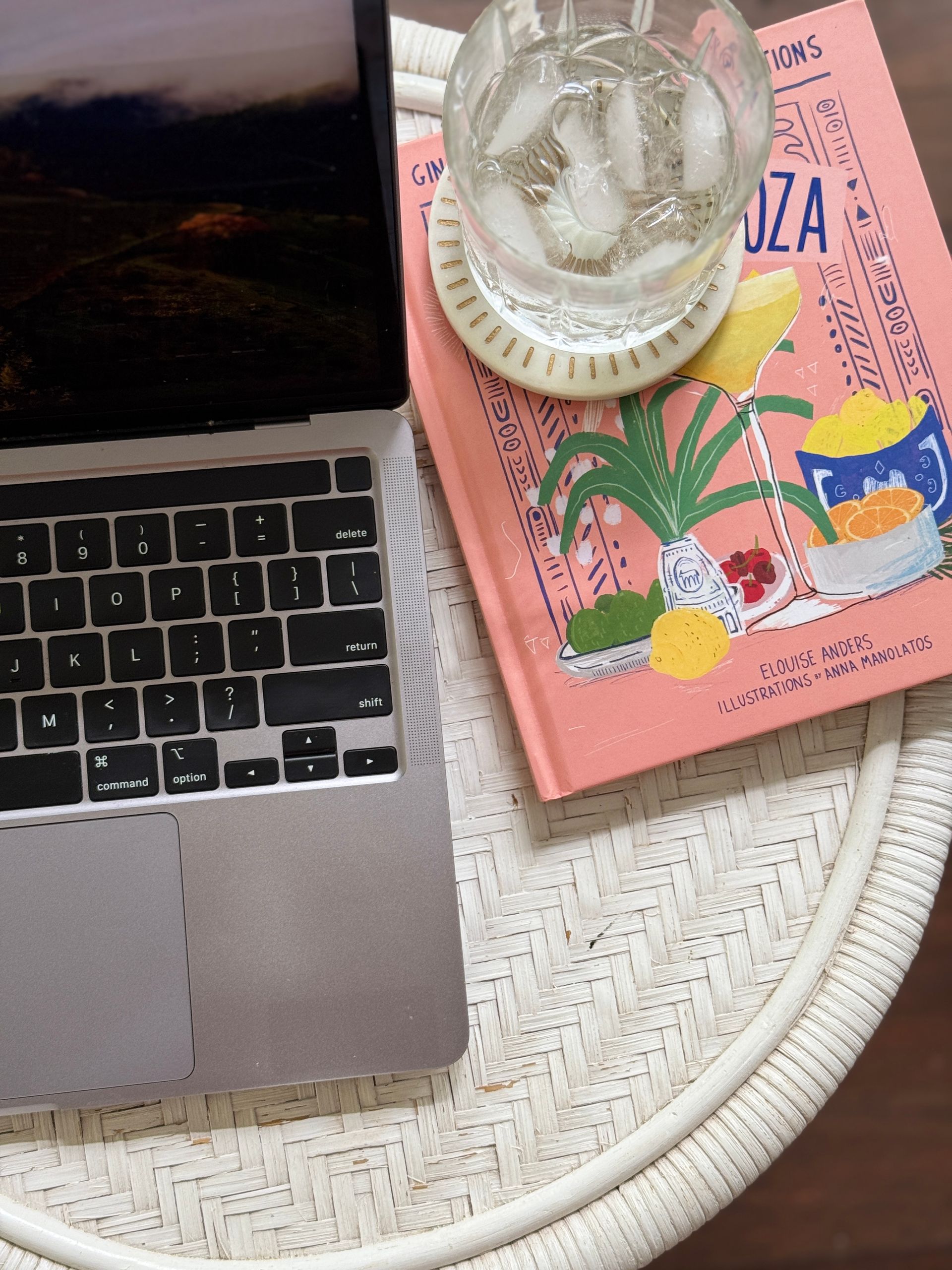 laptop keyboard on table with book and drink