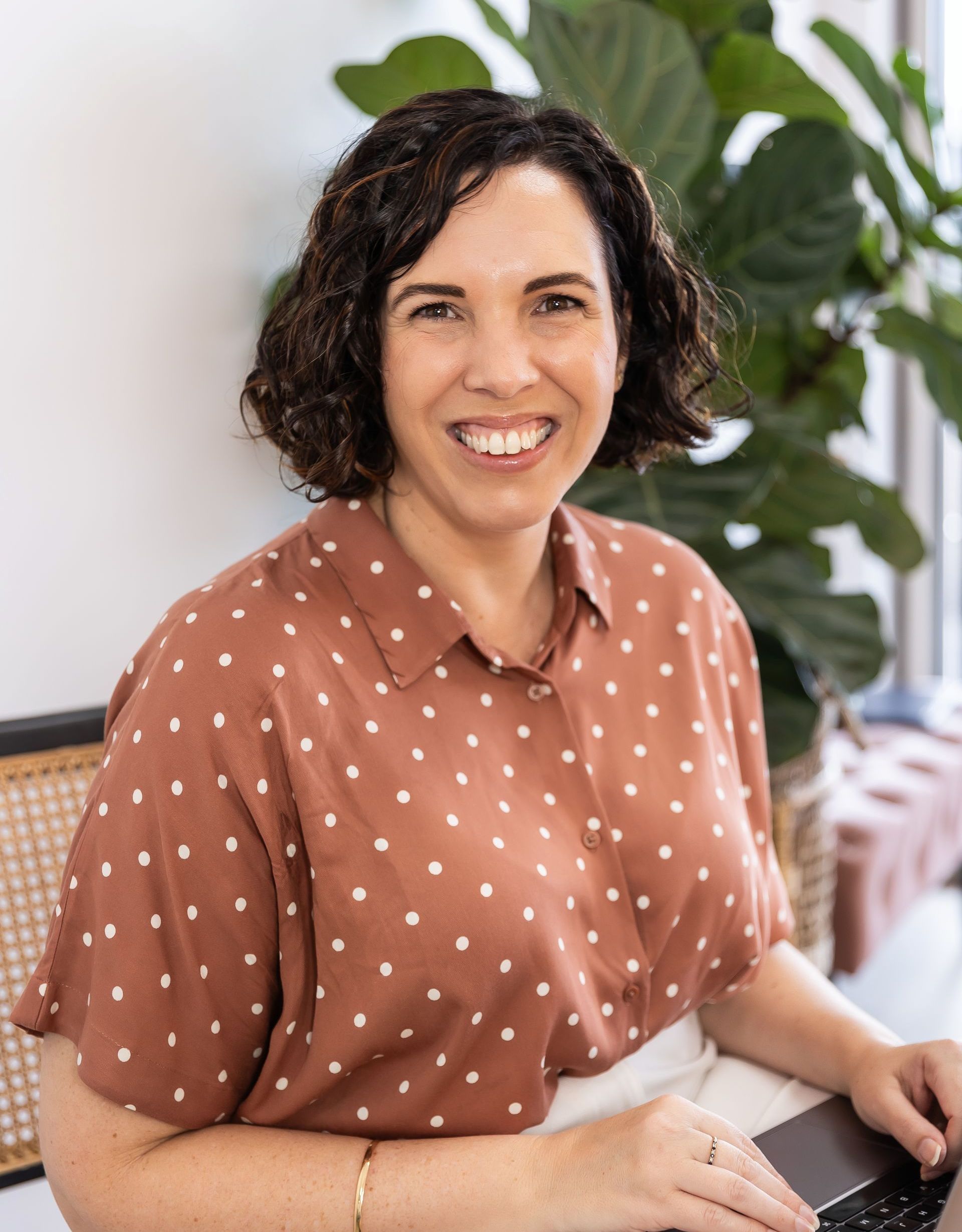 sarah dummer smiling at camera sitting on lounge