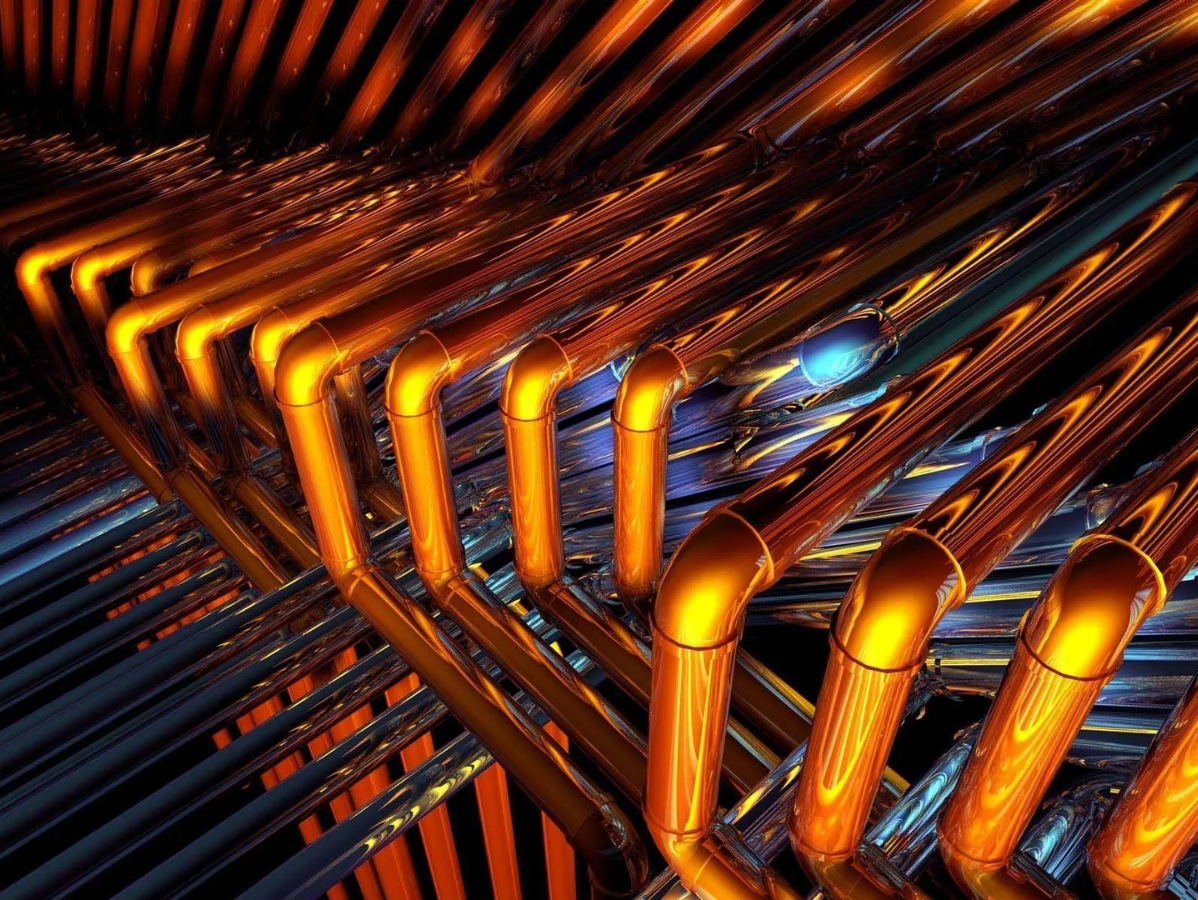 Copper pipes, illuminated orange, arranged in a complex industrial network.