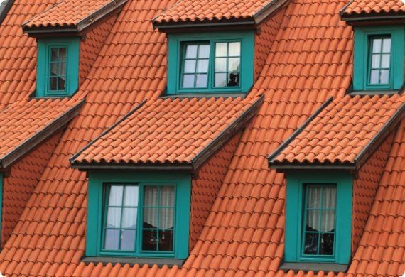 A row of red tiled roofs with green windows