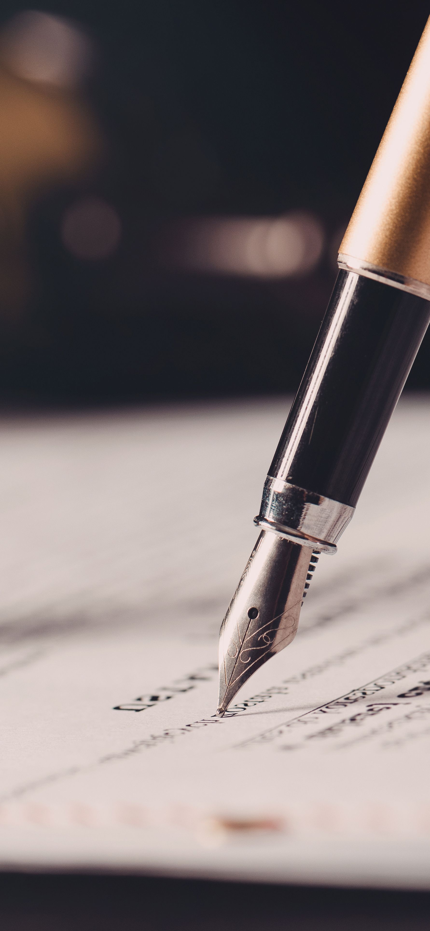 Fountain pen writing on a document. Close-up shot with a dark background.