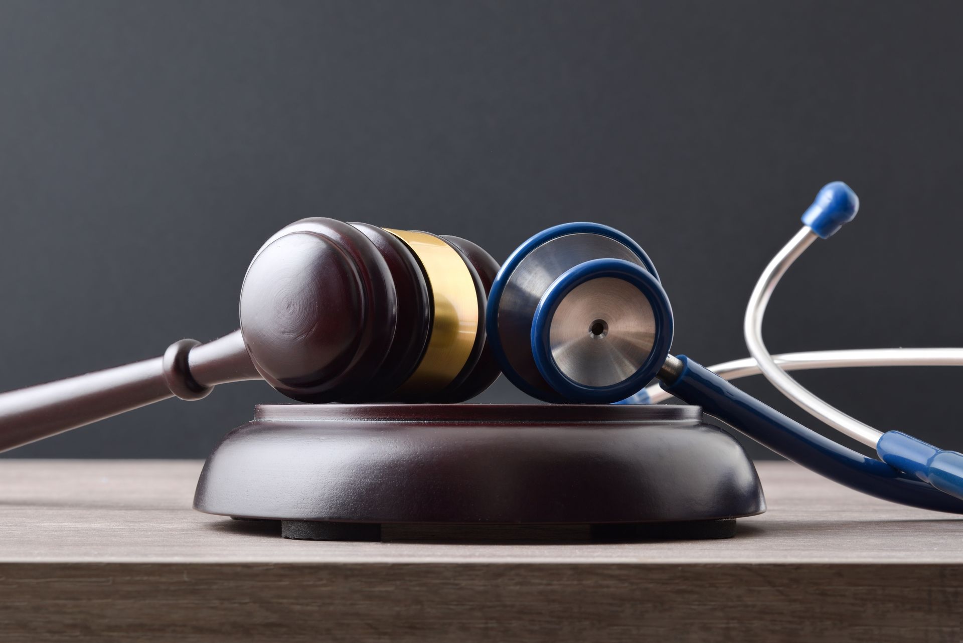 Gavel and stethoscope on a wooden surface, symbolizing medical law or healthcare.
