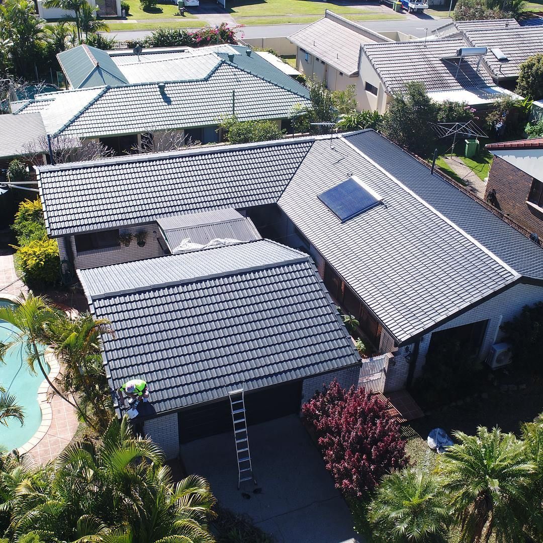 An aerial view of a house with a solar panel on the roof.