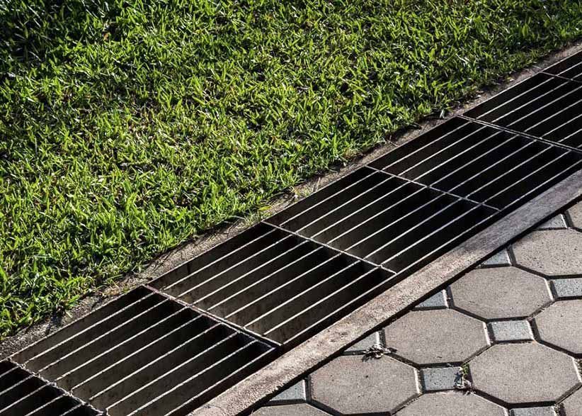 A Close up Of a Metal Drain on A Sidewalk Next to A Grassy Area — Green Vision NT in Virginia, NT
