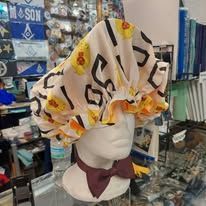 Mannequin wearing a white chef hat with yellow print in a store display