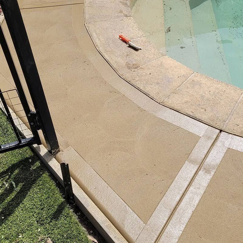 A Concrete Walkway Next to a Swimming Pool With a Marker on It — Dave Smith Concrete in Maitland, NSW