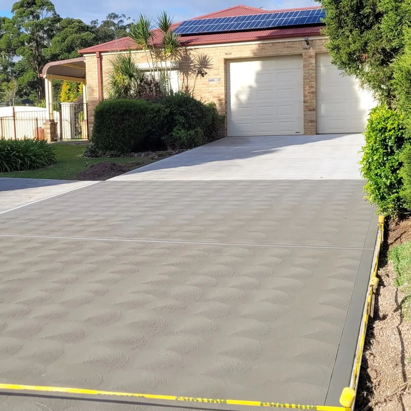 A Newly Concreted Driveway Leading To A House — Dave Smith Concrete in Mallabula, NSW