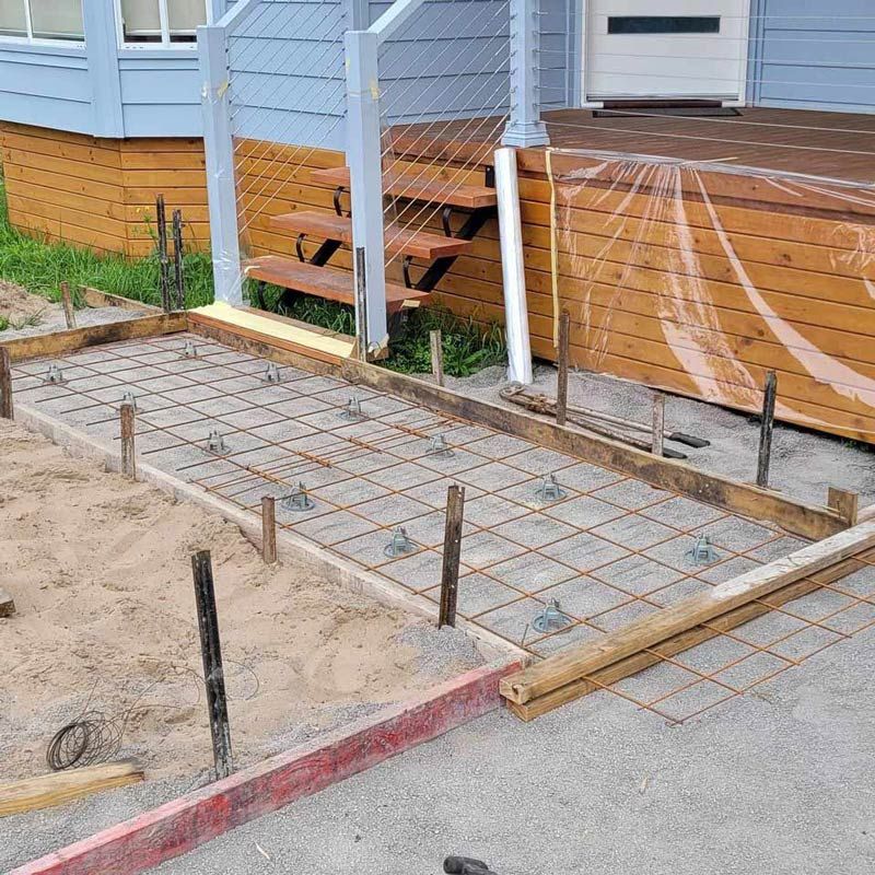 A Concrete Walkway is Being Built in Front of a House — Dave Smith Concrete in Salt Ash, NSW