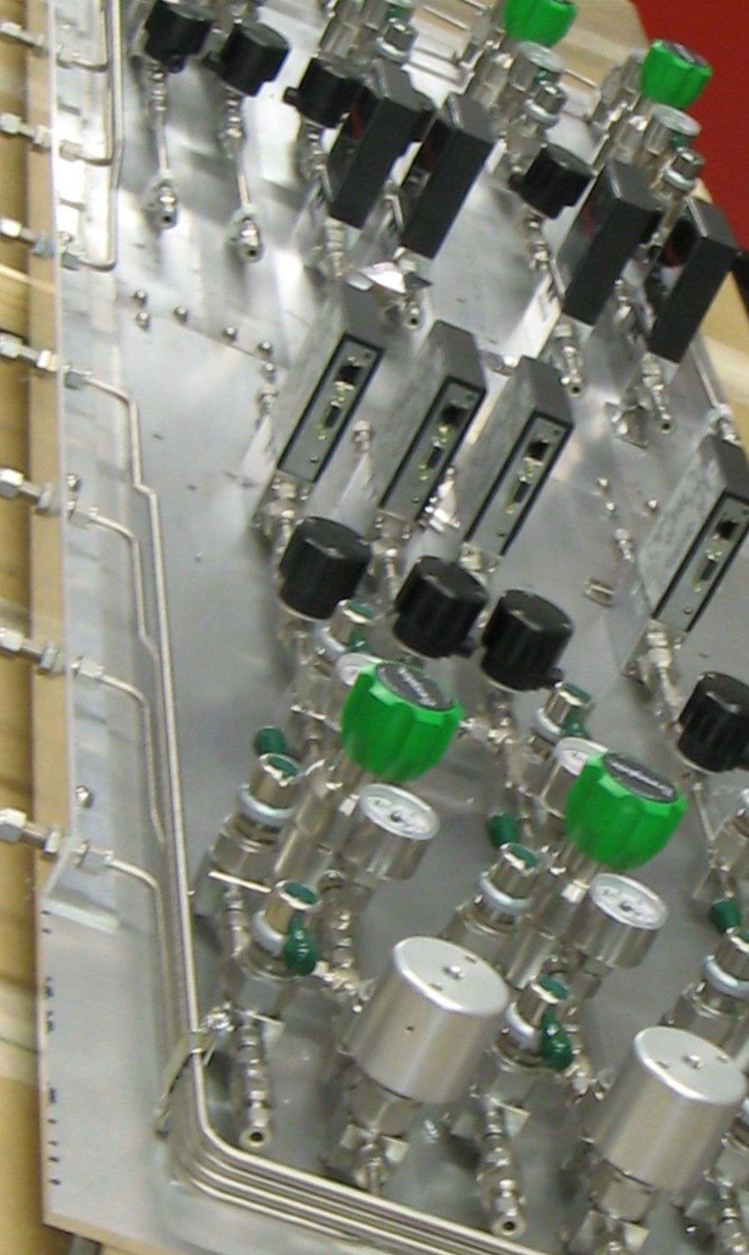 A bunch of valves with green knobs on them
