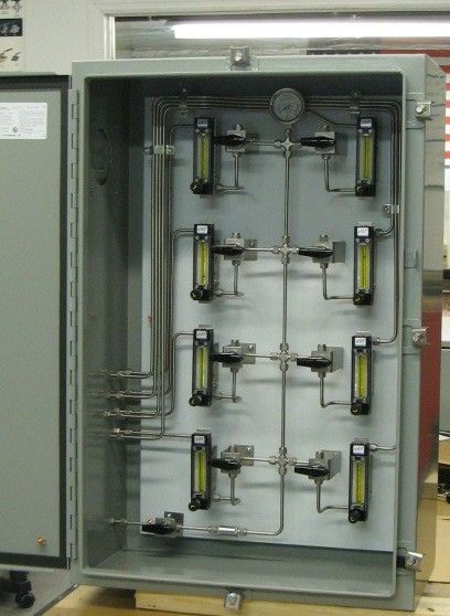 A metal box with a bunch of pipes and gauges on it