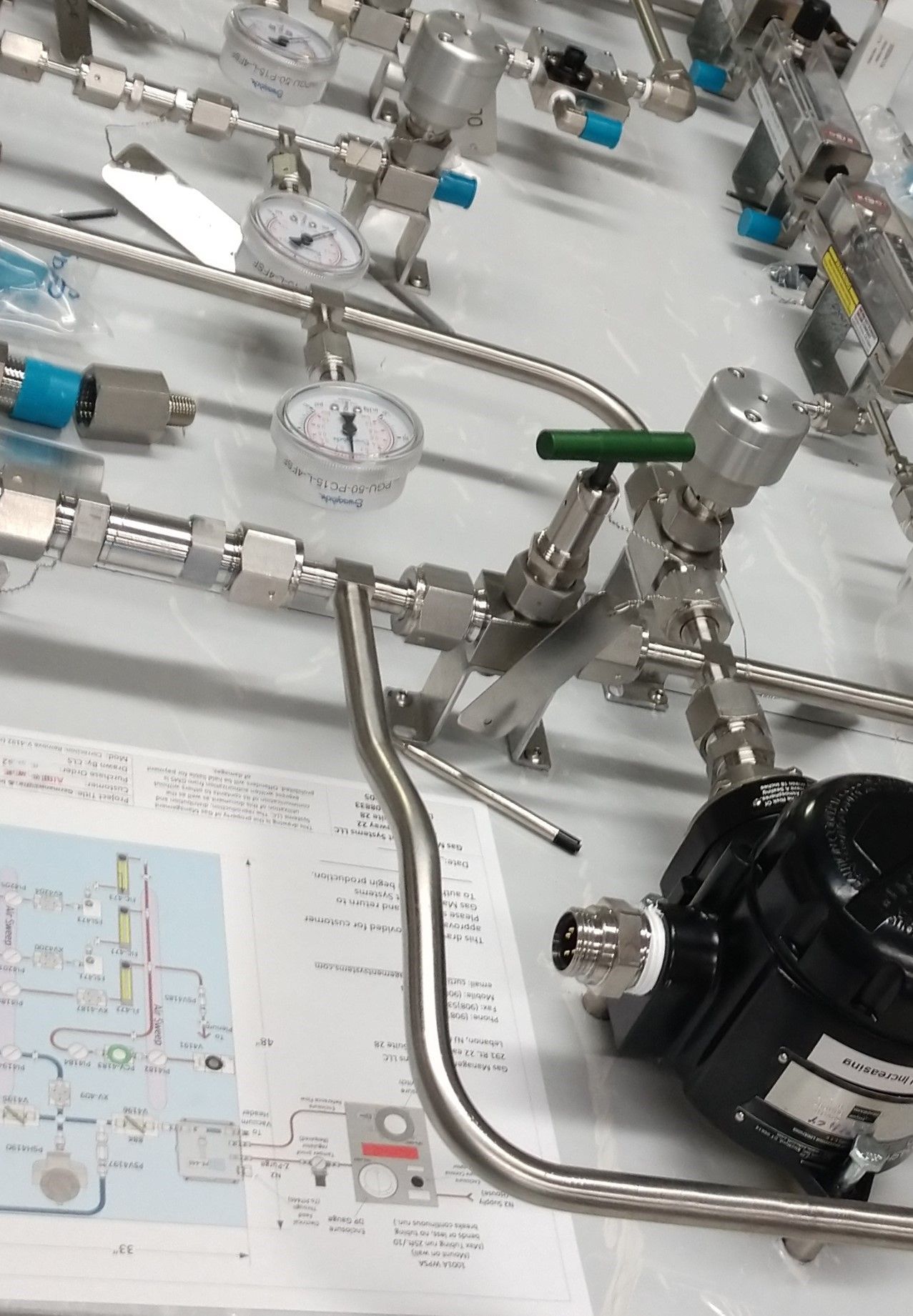 A bunch of stainless steel pipes and gauges on a table