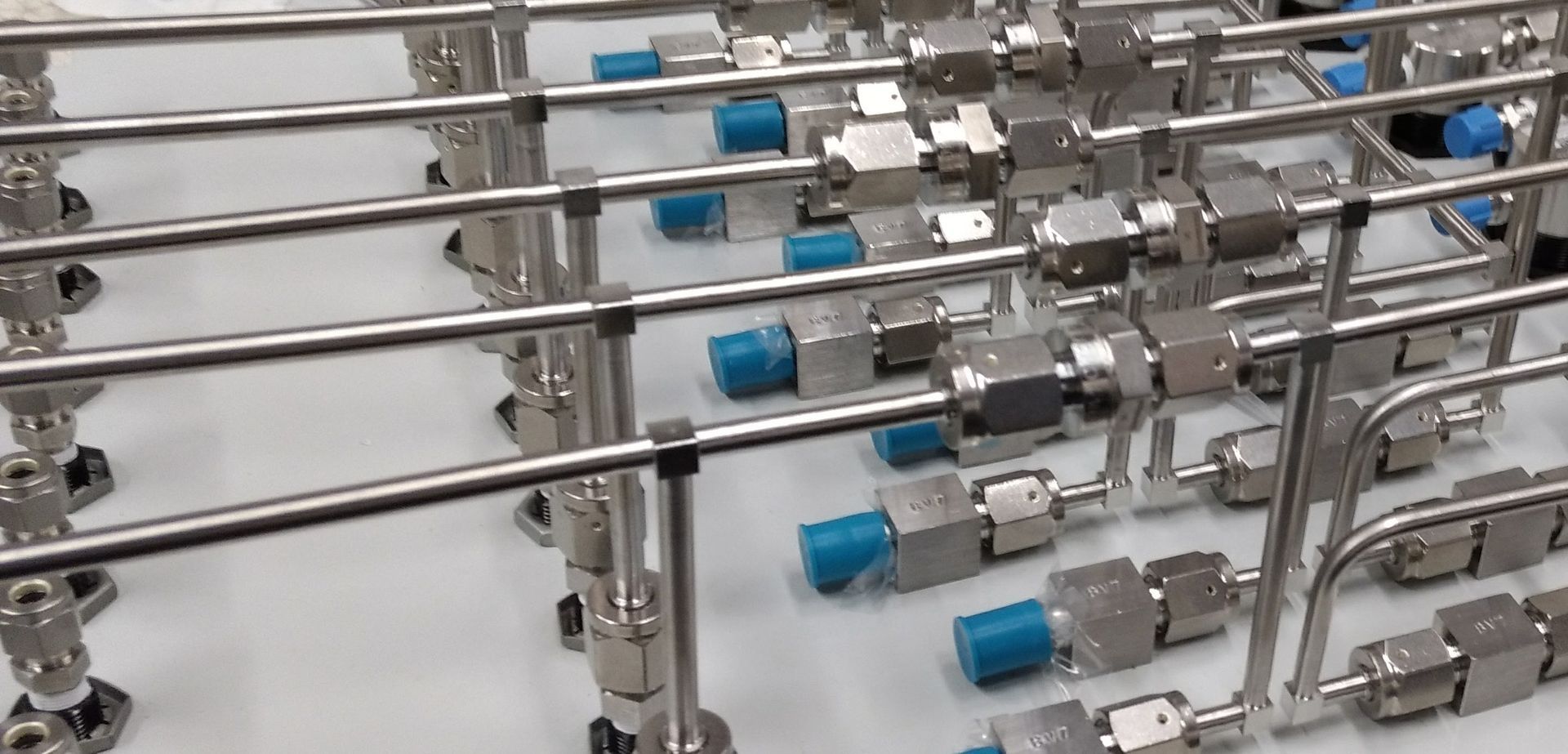 A bunch of stainless steel pipes are sitting on top of each other on a table.