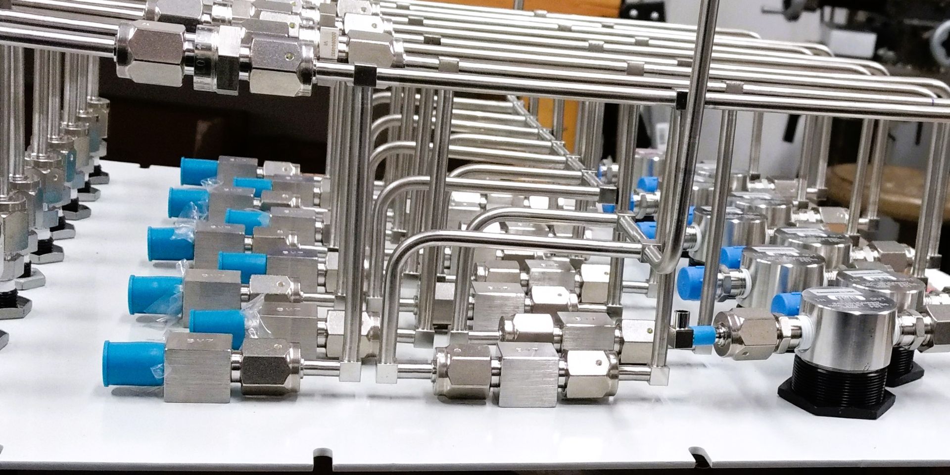 A bunch of stainless steel pipes are lined up on a table.