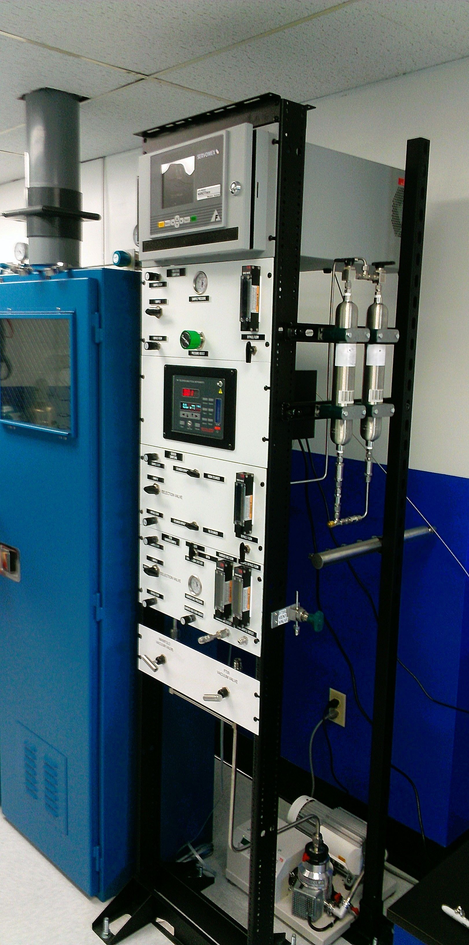 A machine is sitting in a room next to a blue cabinet.