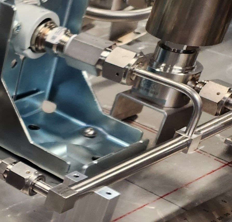 A close up of a machine with stainless steel pipes