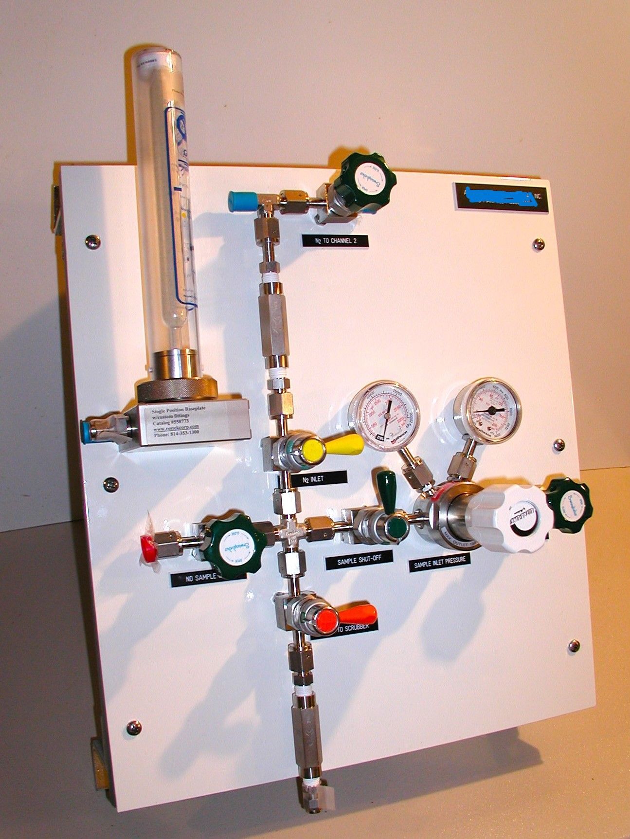 A white board with a bunch of valves and gauges on it