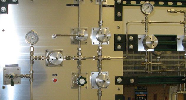 A wall with a bunch of pipes and gauges on it