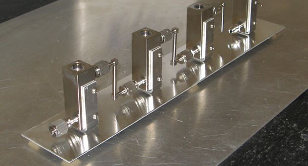 A row of metal pieces are sitting on a metal surface.
