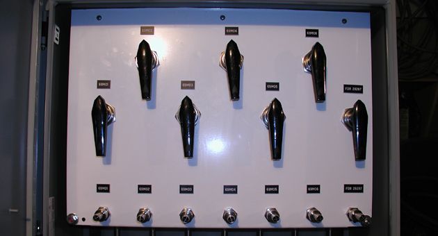 A white board with a bunch of black knobs on it