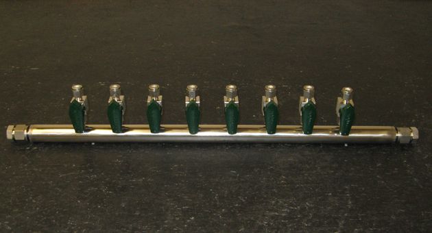 A stainless steel pipe with green handles on it