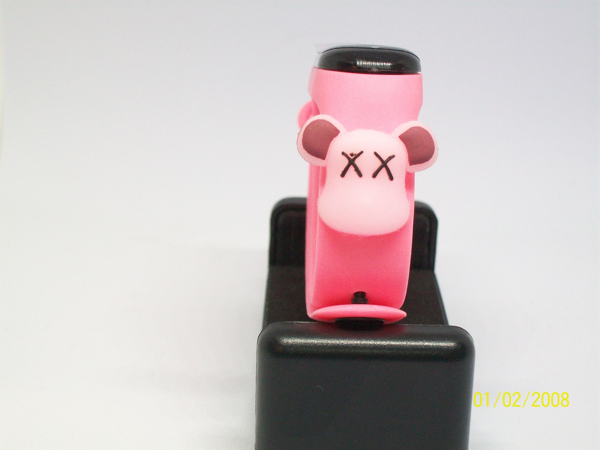 Witte fitnesstracker op een rood oppervlak, met een zwart scherm en roze accenten; gemerkt met Sigma 