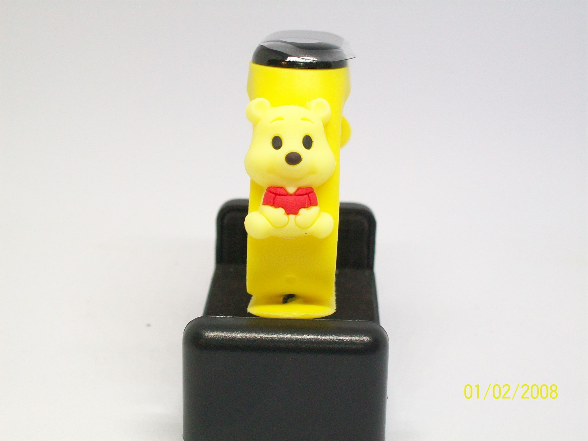 Gele fitnesstracker op een rood oppervlak met een zwart label met de tekst 