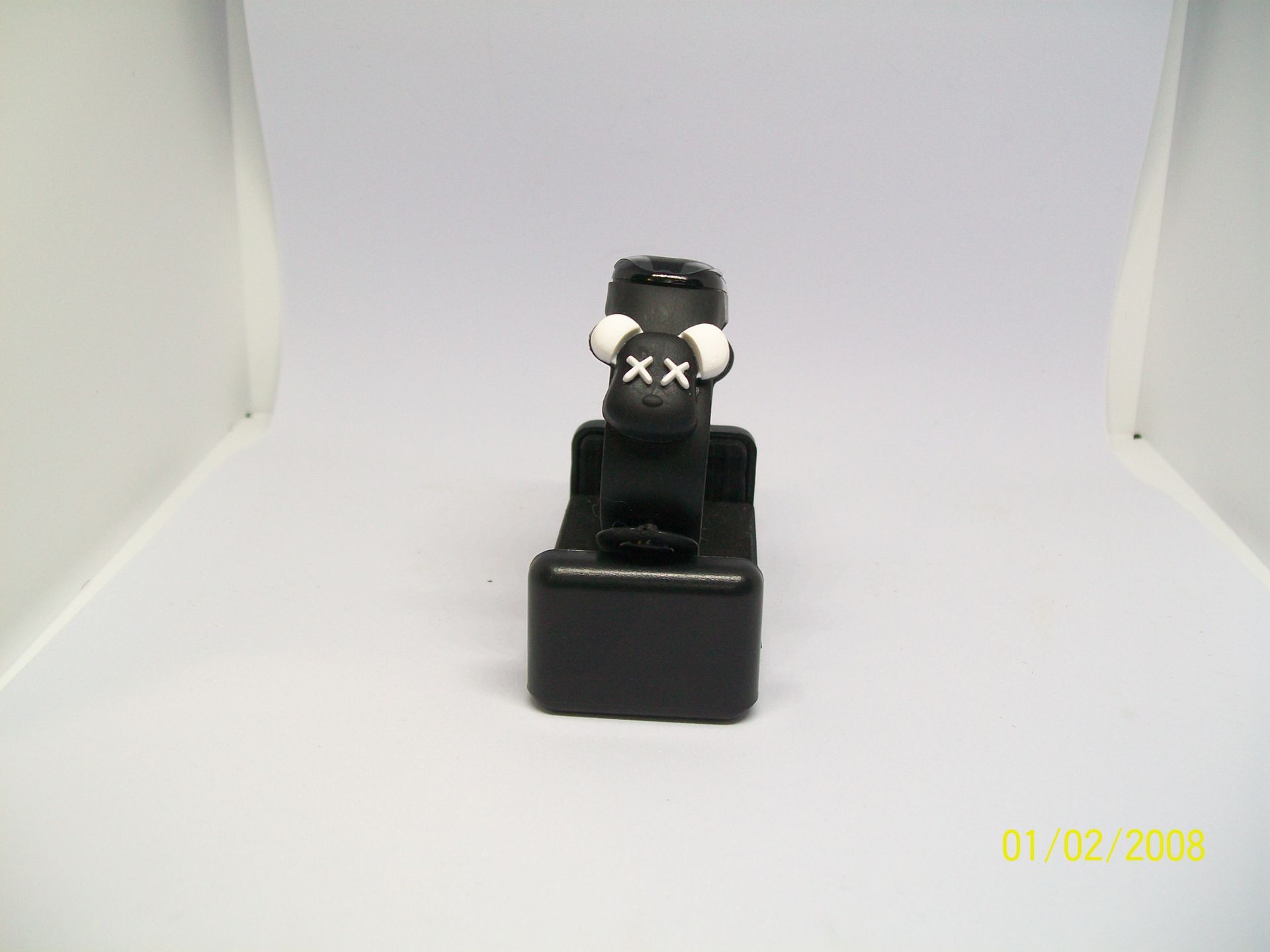 Zwarte fitnesstracker op een rood oppervlak, mogelijk een lenzendoosje.