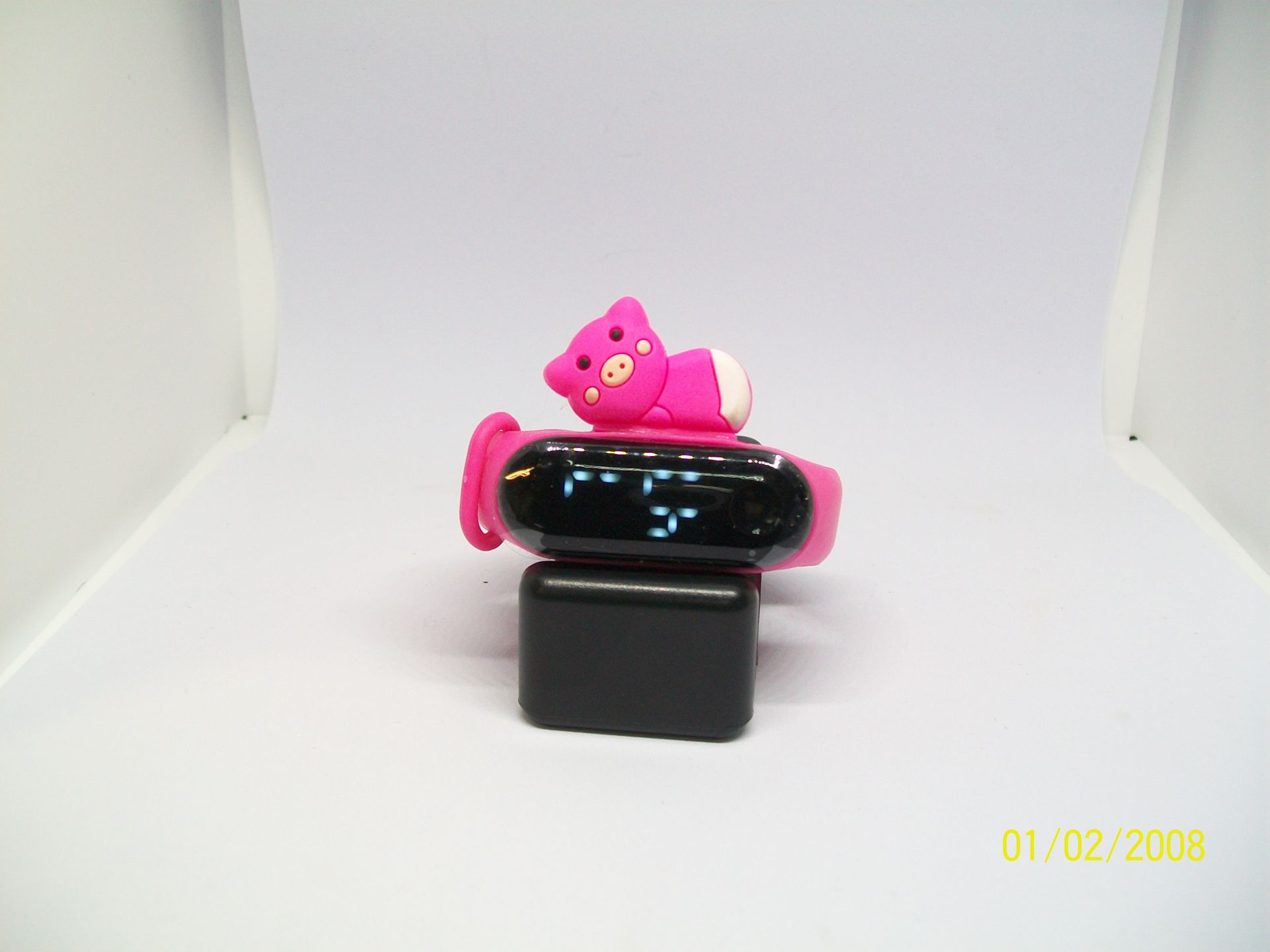 Roze smartwatch met konijnenmotief op een rood oppervlak met het label 