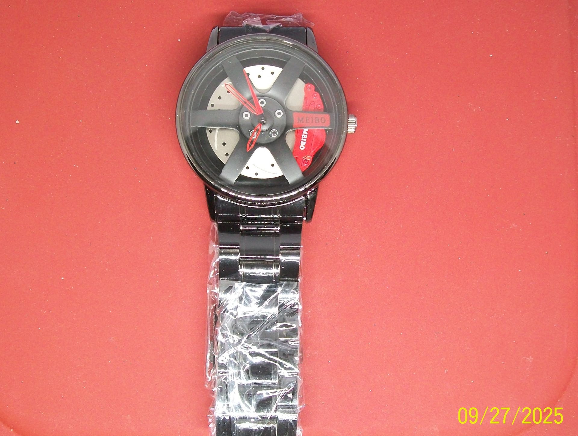 Zwart polshorloge met wieldesign; rode remklauw is zichtbaar.