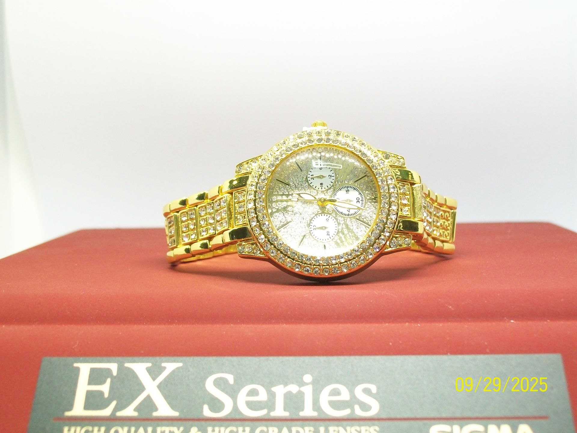 Gouden polshorloge bedekt met kleine, glimmende edelstenen.