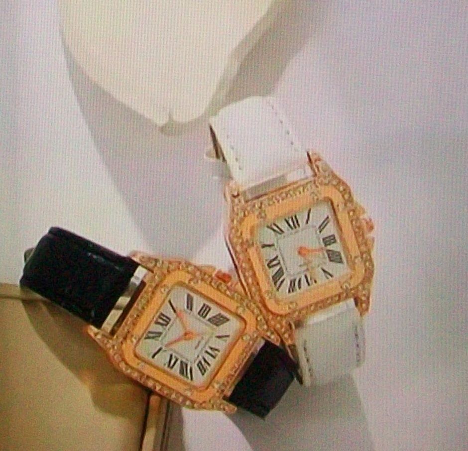 Twee gouden horloges met vierkante wijzerplaten bezet met diamanten, één met een witte band, de ander met een zwarte band.