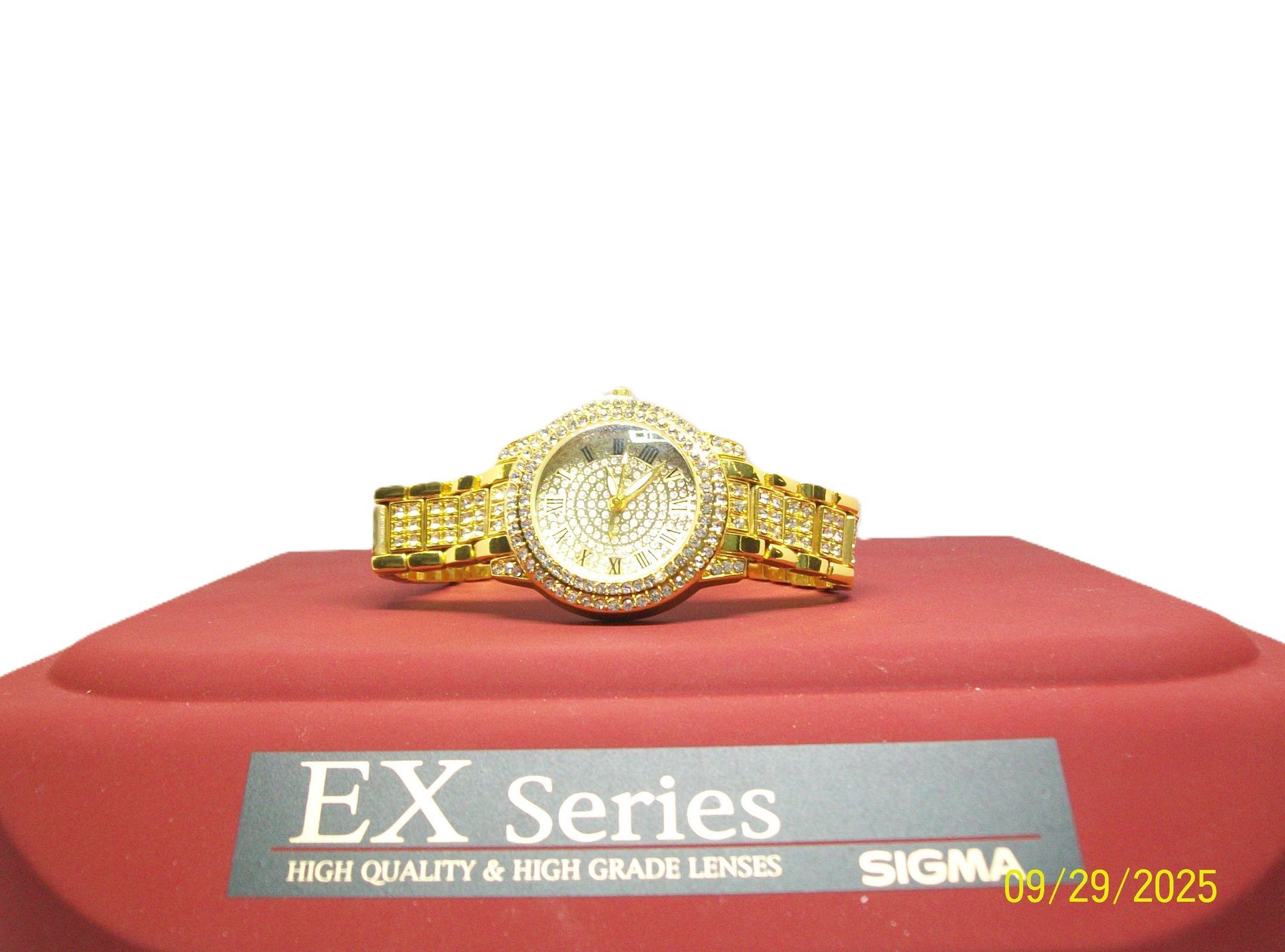 Gouden, met diamanten bezette polshorloge op een rood oppervlak met zichtbare 