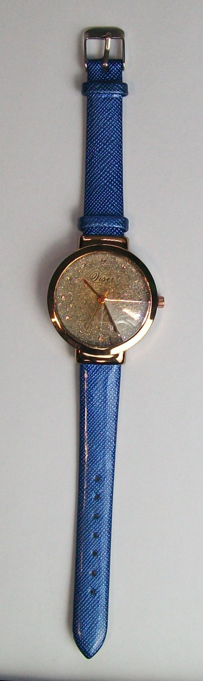 Een blauw horloge met een glinsterende gouden wijzerplaat en een blauw gebloemde band.