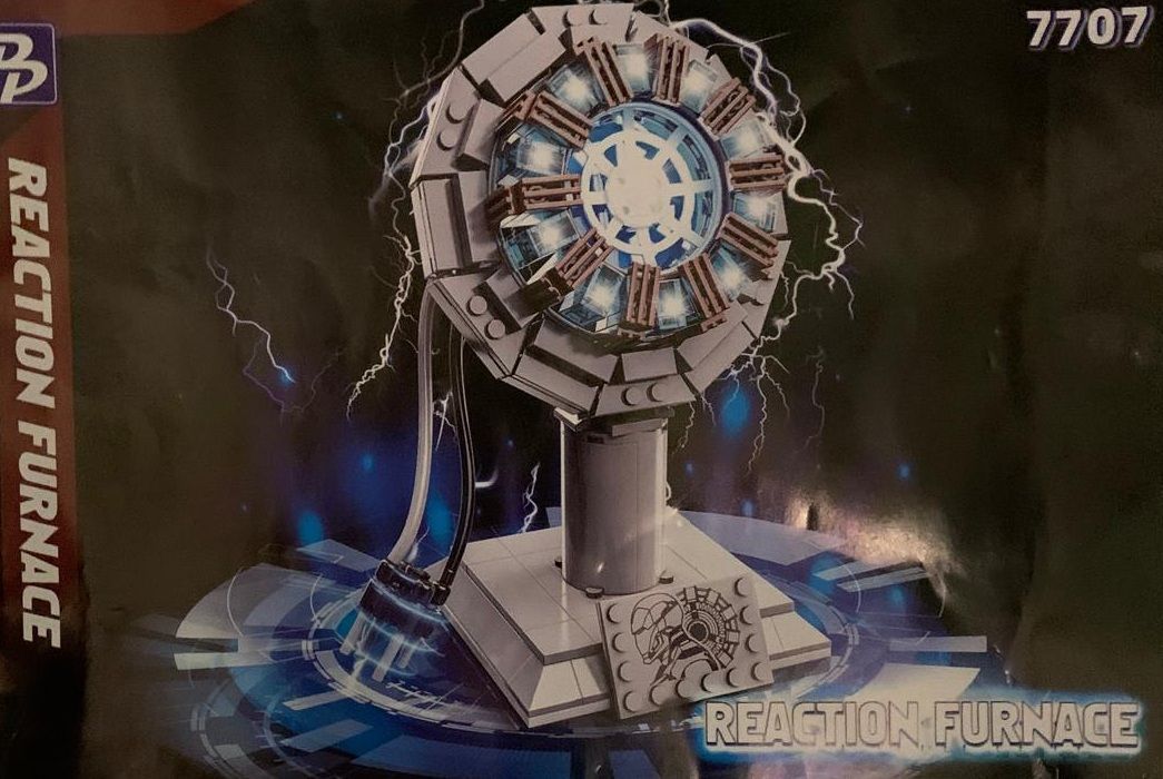 Iron Man Arc Reactor model gemaakt van bouwstenen. Geassembleerd en verspreid over een houten oppervlak.