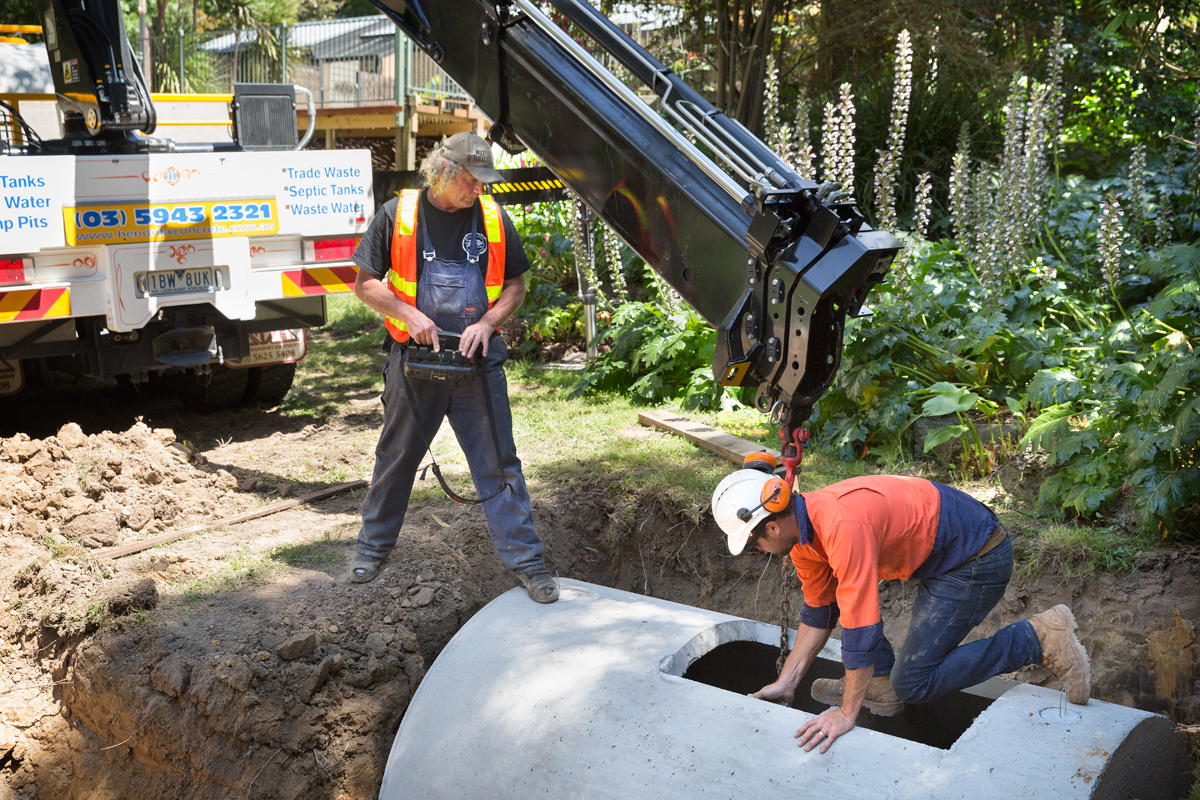 Workers inspecting a septic system in a trench