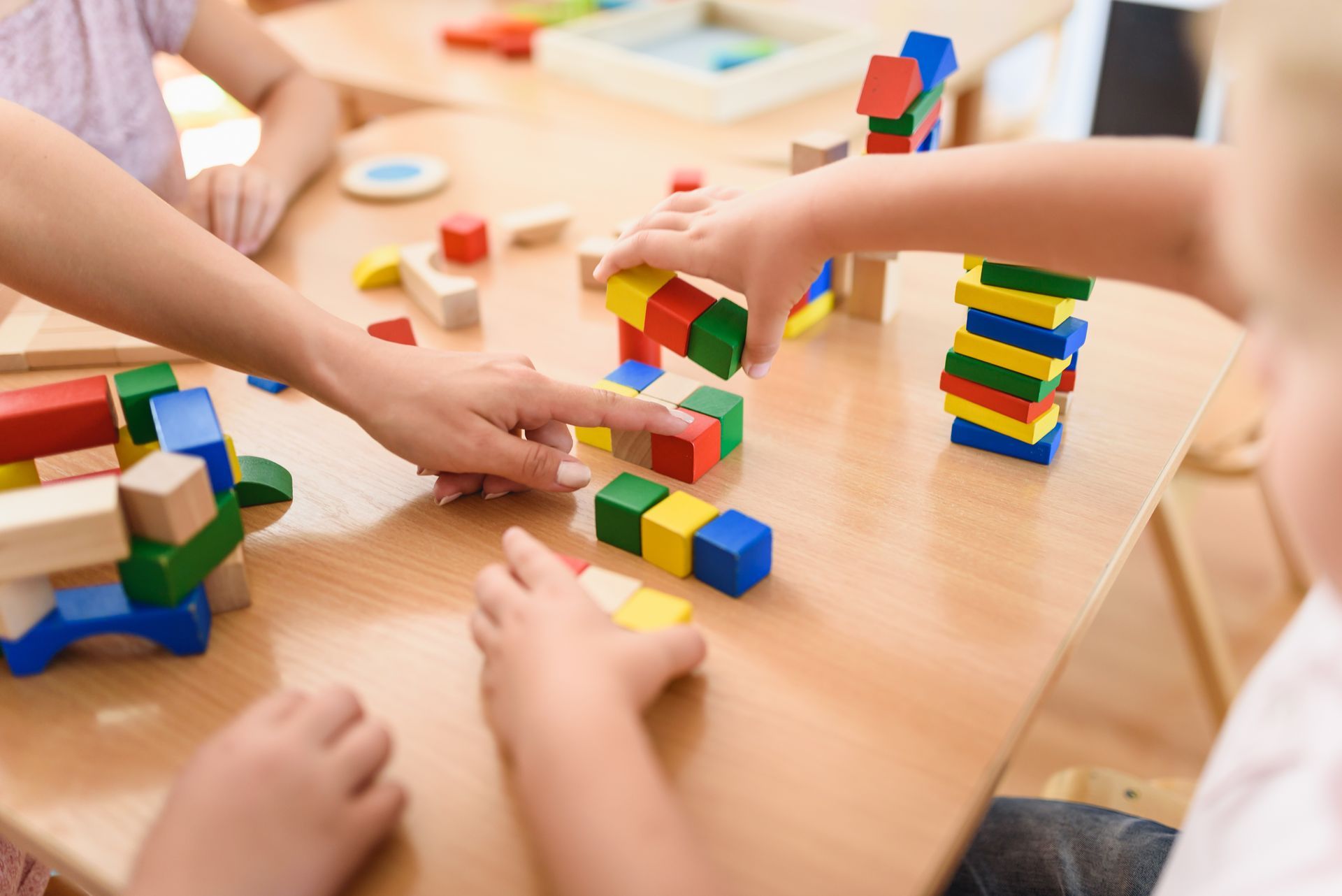 Preschool teacher with children playing with toys, showcasing STEAM integrated programs in class. Preschool teacher with children playing with toys, showcasing STEAM integrated programs in class.