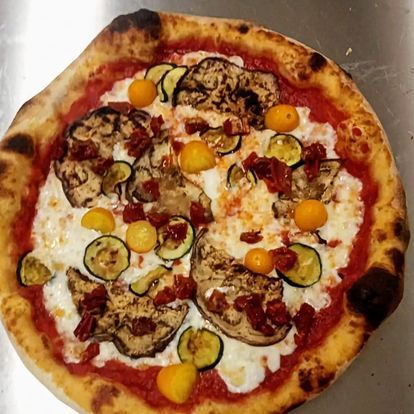Una pizza con tante verdure sopra