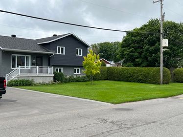 Un camion est garé devant une maison avec une grande pelouse.
