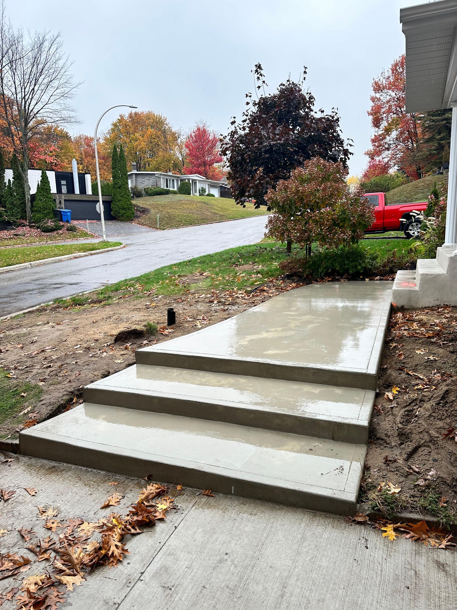 Une passerelle en béton est en cours de construction devant une maison.